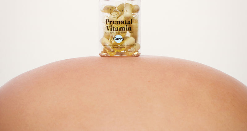 Premama® Prenatal Vitamin on a pregnant stomach