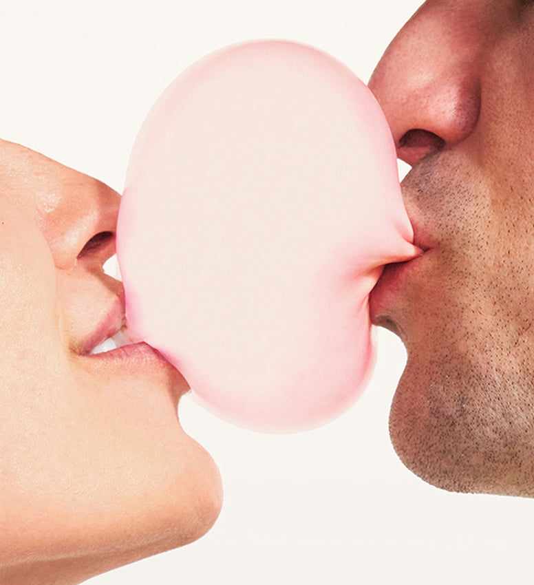 Couple blowing bubble with gum
